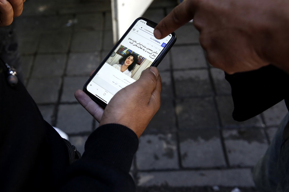 Iranians read a news report about the Nobel Peace Prize winner Iranian women