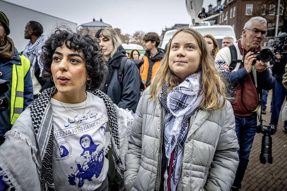 Swedish climate activist Greta Thunberg (R) and Sahar Shirzad (L), co-founder of the collective Azadi and winner of the PAX Peace Dove 2023, take part in a march for climate and justice in Amsterdam, The Netherlands, November 12, 2023. Robin Utrecht, EPA-EFE.