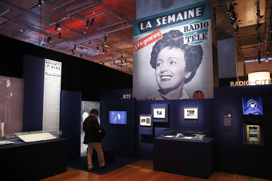 A visitor look at pictures and videos of French singer Edith Piaf on display during the exhibition 