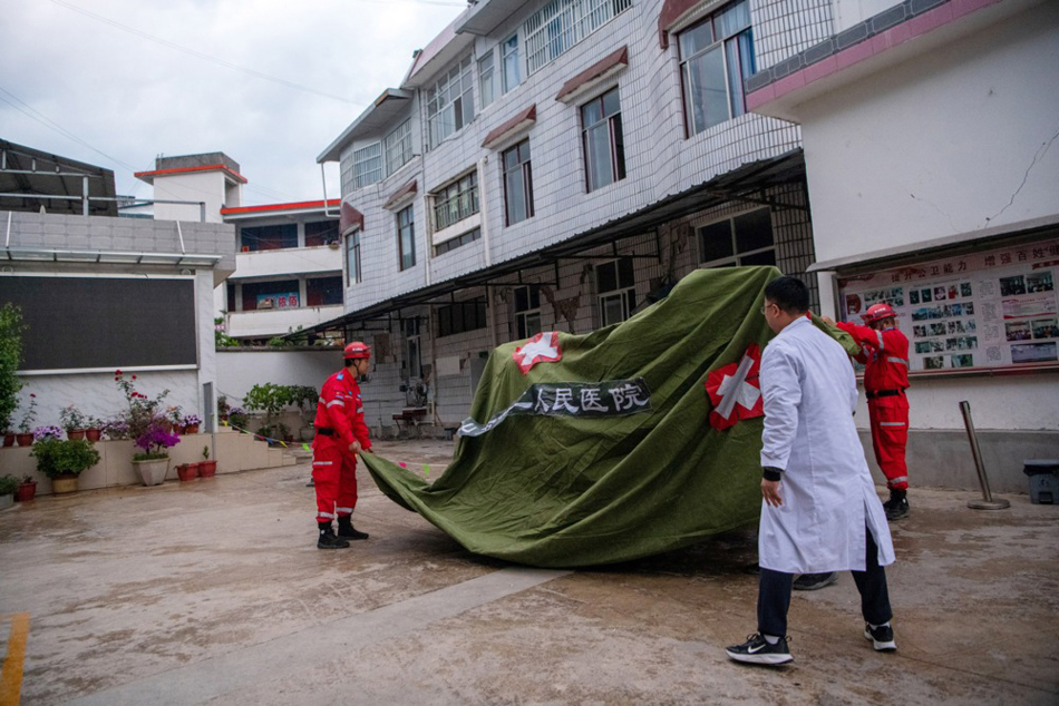 Rescuers put up a tent at a clinic in Wayao Township, Longyang District of Baoshan City, southwest China