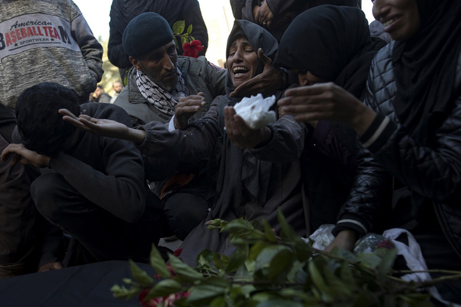 The mother of a Palestinian man from the Al-Amour family, who was killed during Israeli air strikes on the southern Gaza Strip, mourns over his wrapped body, outside Nasser Hospital in Khan Yunis, southern Gaza Strip, on December 24, 2023. Haitham Imad, EPA-EFE