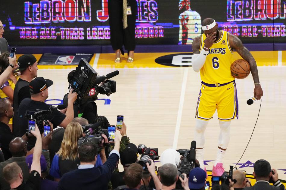 Los Angeles Lakers forward LeBron James (R) stands with the basketball after becoming the all-time leading scorer in NBA history. Allison Dinner, EPA-EFE.