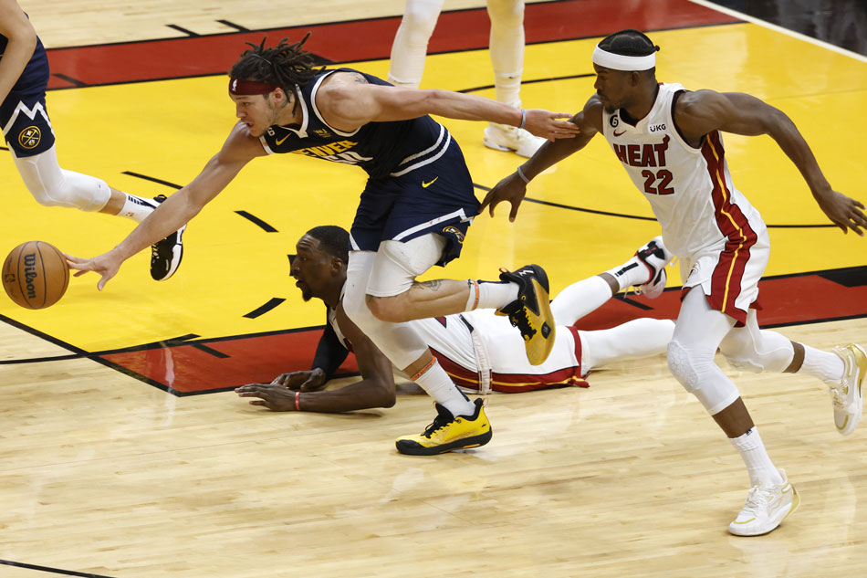 Denver Nuggets forward Aaron Gordon (C) reaches a loose ball away from Miami Heat center Bam Adebayo (bottom, L) and Jimmy Butler (R) during the first half of Game 4 of the NBA Finals at the Kaseya Center in Miami, Florida, USA, June 9, 2023. Rhona Wise, EPA-EFE.