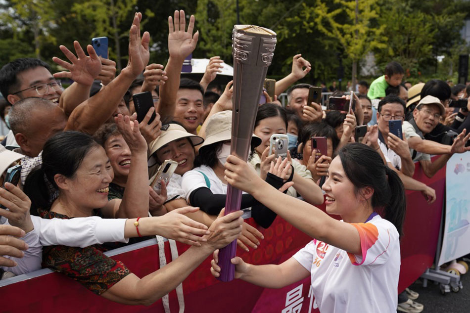 People react as torch bearer Jiang Lijuan (R) attends the torch relay of the 19th Asian Games in Hangzhou, Zhejiang province, China. EPA-Han Chuanhao, EPA-EFE/XINHUA