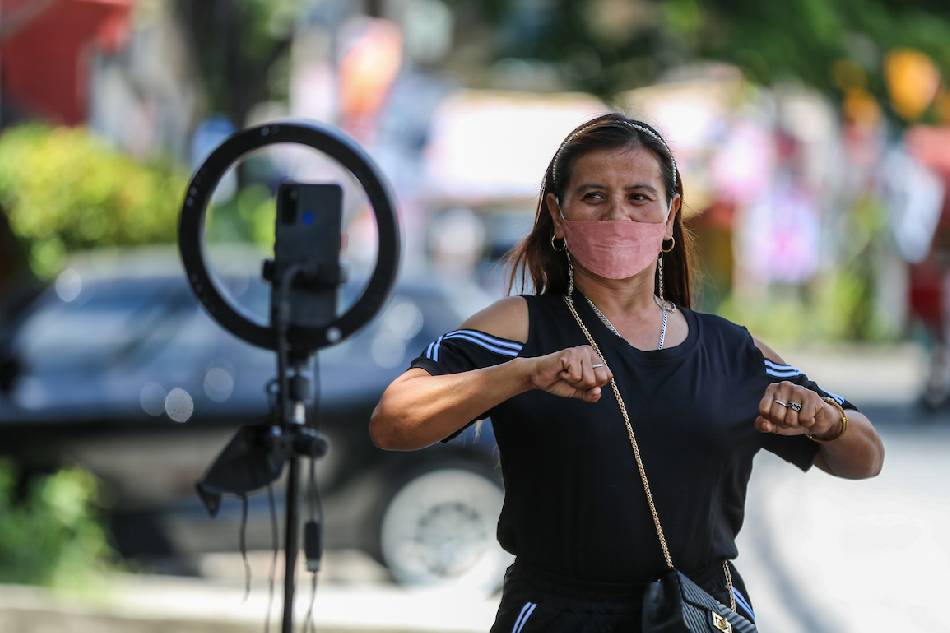 Swan Anding Meraluo dances in front of a mobile phone rig hoping that 2 performances a day for her TikTok account might hit a jackpot of 'likes', in Quezon City on May 4, 2022. Jonathan Cellona, ABS-CBN News/File