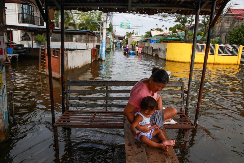 Residents try to cope with the flood situation in Barangay Batasan, Macabebe, Pampanga on Aug. 8, 2023. Heavy rains brought by typhoon Egay and Falcon as well as the enhance southwest monsoon caused many parts of Pampanga and Bulacan flooded for almost a month. Jonathan Cellona, ABS-CBN News 