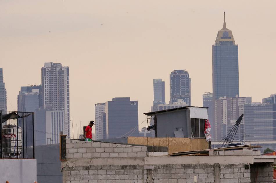 A man works on top of an unfinished structure in Taguig City on January 11, 2023. George Calvelo, ABS-CBN News