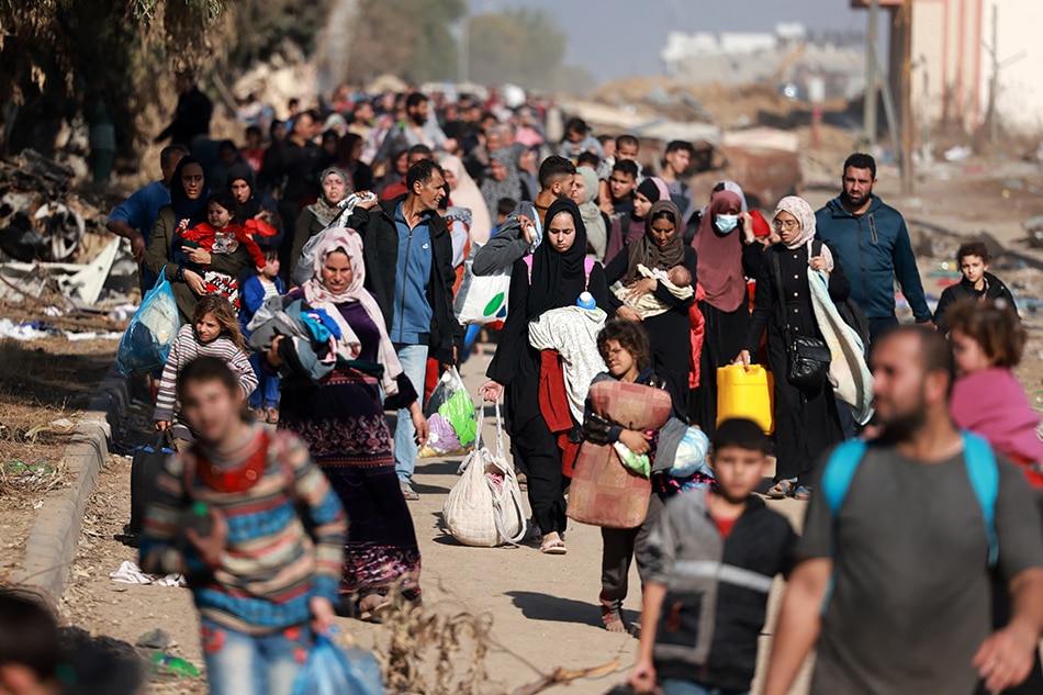 Palestinians fleeing Gaza City and other parts of northern Gaza, carry some belongings as they walk along a road leading to the southern areas of the enclave on November 18, 2023, amid ongoing battles between Israel and the Palestinian Hamas movement. Mohammed Abed, AFP.