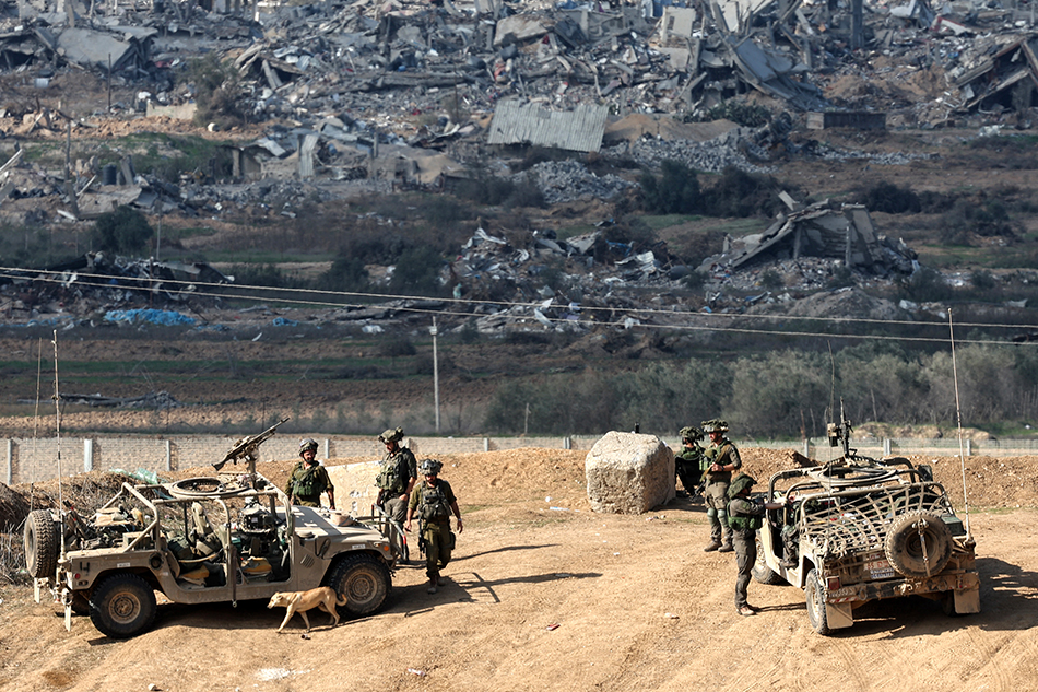Israeli army soldiers stand guard at a position near the Israeli-Gaza border, overlooking the Shujaiya neighborhood in the Gaza Strip, in southern Israel, December 29, 2023. Atef Safadi, EPA-EFE. 