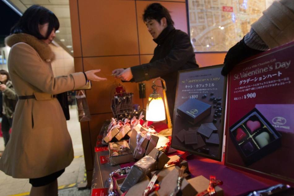 A Japanese woman buys chocolates at a pop-up kiosk, just a day before Valentine