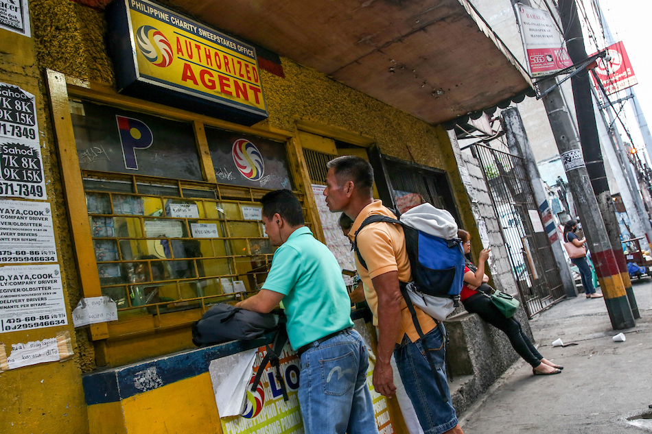 People place their bets at a Philippine Charity Sweepstakes Office (PCSO) authorized lotto outlet in Sta Mesa Manila, July 31, 2019. Jonathan Cellona, ABS-CBN News/File.