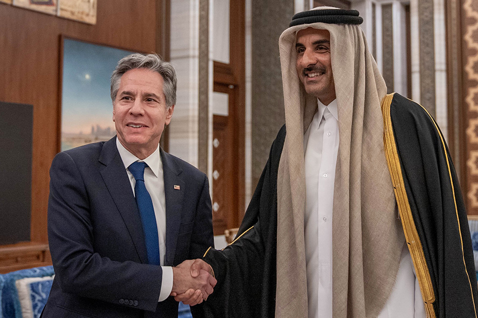 A handout photo made available by the Amiri Diwan of the State of Qatar shows US Secretary of State Antony Blinken (L) shakes hands with Qatar