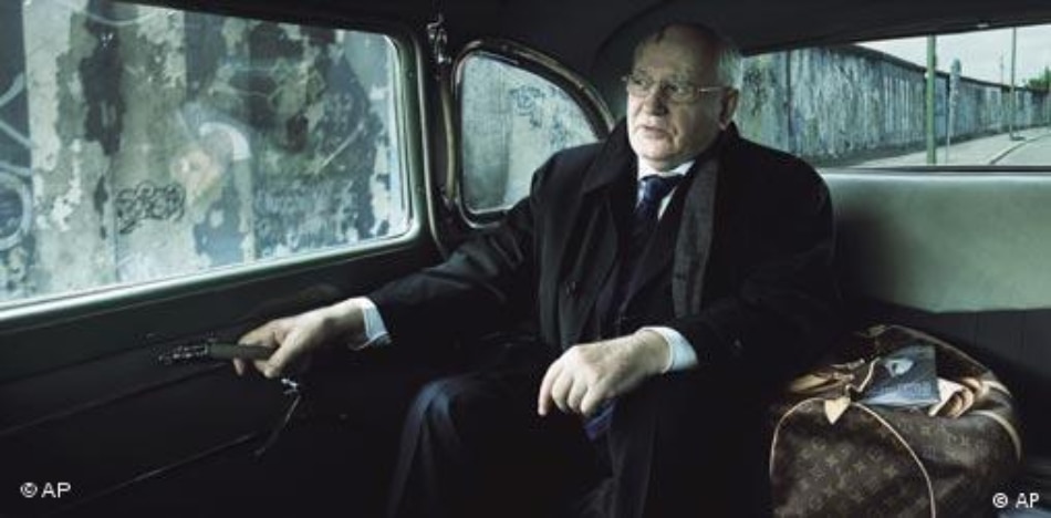 Mikhail Gorbachev with a Louis Vuitton bag and the Berlin Wall in the background