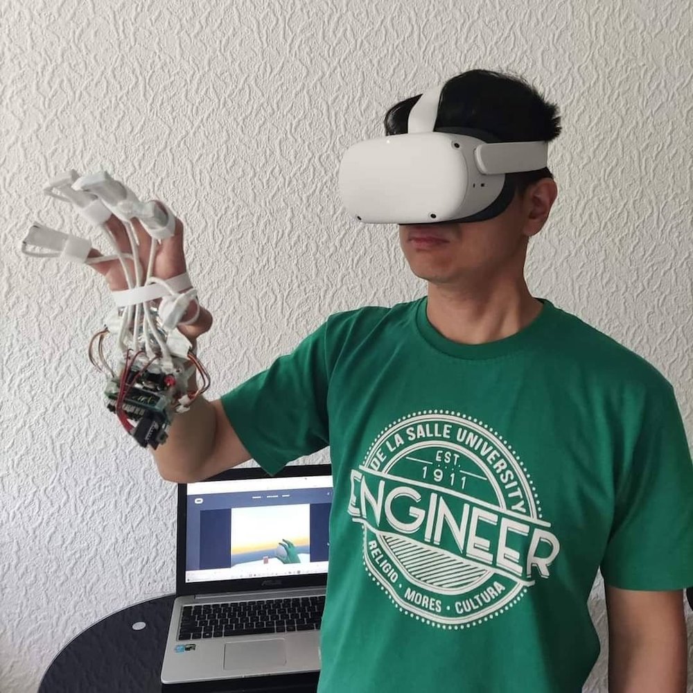 A wireless fine-grained haptic hand wearable with 16 tactile pins on each fingertip connected to a Quest 2 VR headset.
