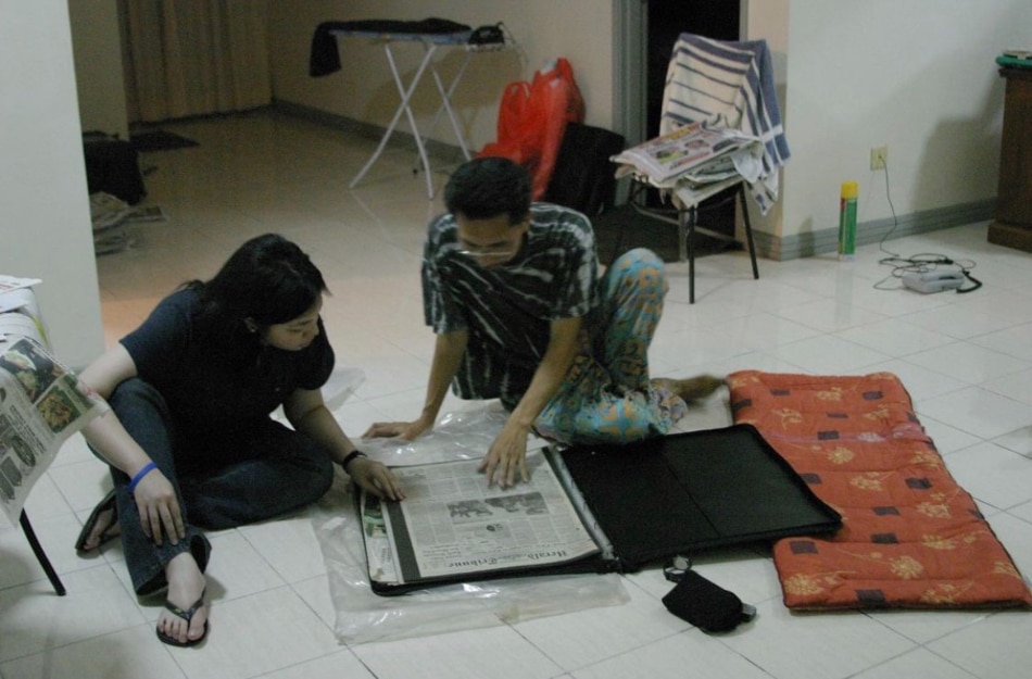 Gacad, with mentee David, going thru tear sheets of his reportage. Photo from Tammy David
