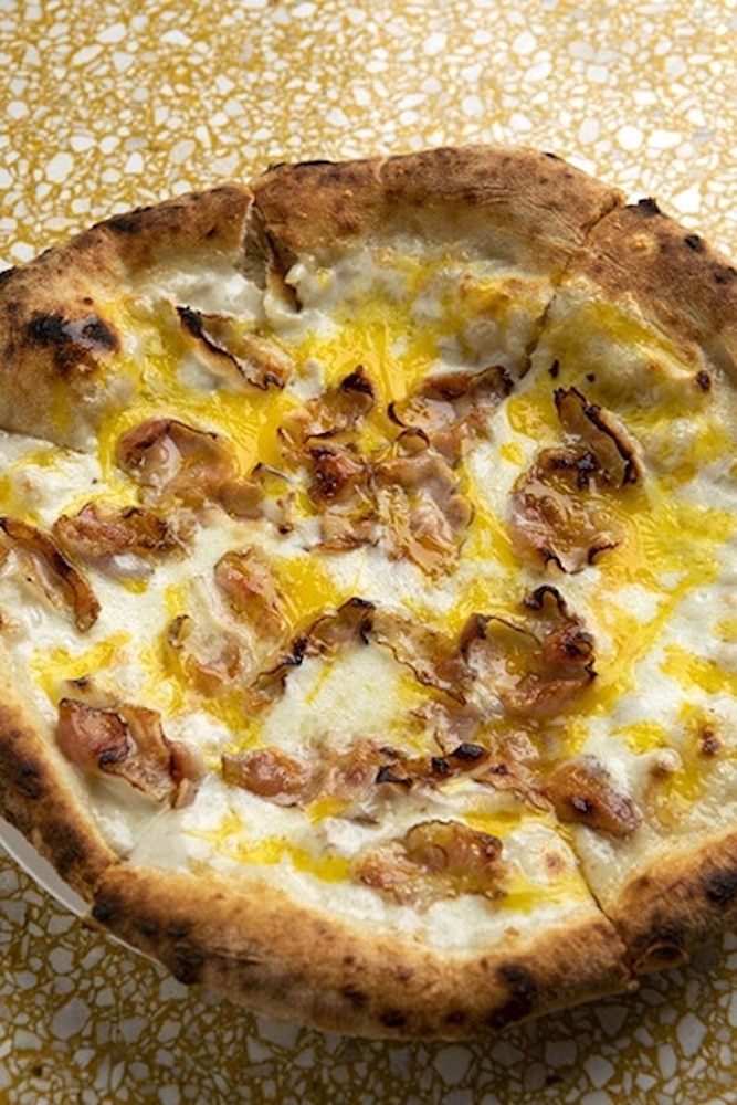 a mano's Neapolitan-style Carbonara Pizza with guanciale or cured pork jowl, cheese, and egg.