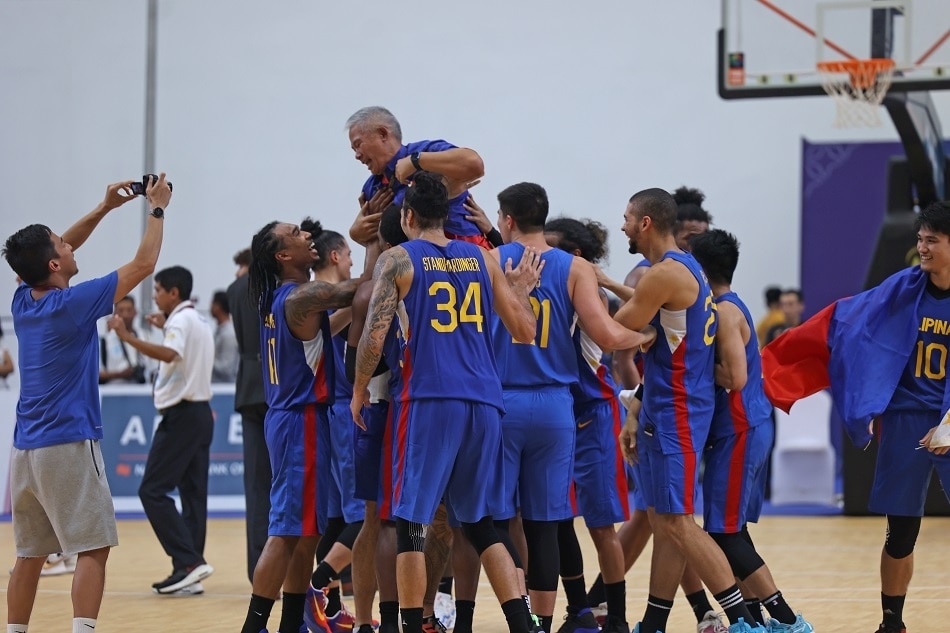 Gilas Pilipinas players give coach Chot Reyes a victory ride after their victory in the gold medal game of the 32nd SEA Games against Cambodia