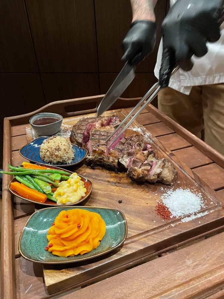 Freshly seared Tomahawk from William Watson comes with steak rice, mixed vegetables, sweet mashed potato, Truffle Madeira sauce and potato gratin.